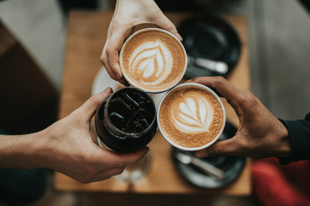 Friends raising cups of coffee together